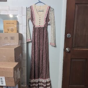 This is a Candi Jones vintage 1970s prairie maxi dress with a brown and pink flo